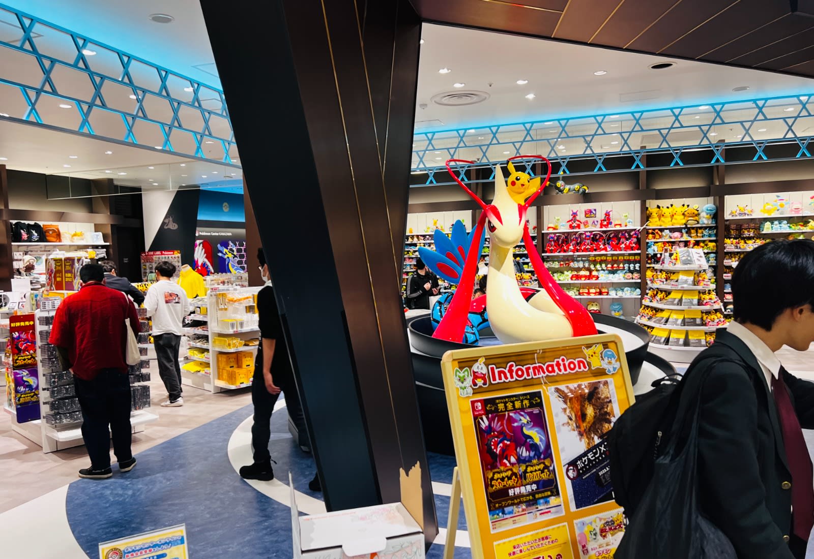Visitors explore the Pokémon Center in Kanazawa, Japan, filled with vibrant Pokémon merchandise and a large statue of Pikachu riding Milotic. A must-visit for families and fans on a Honshu Japan itinerary.
