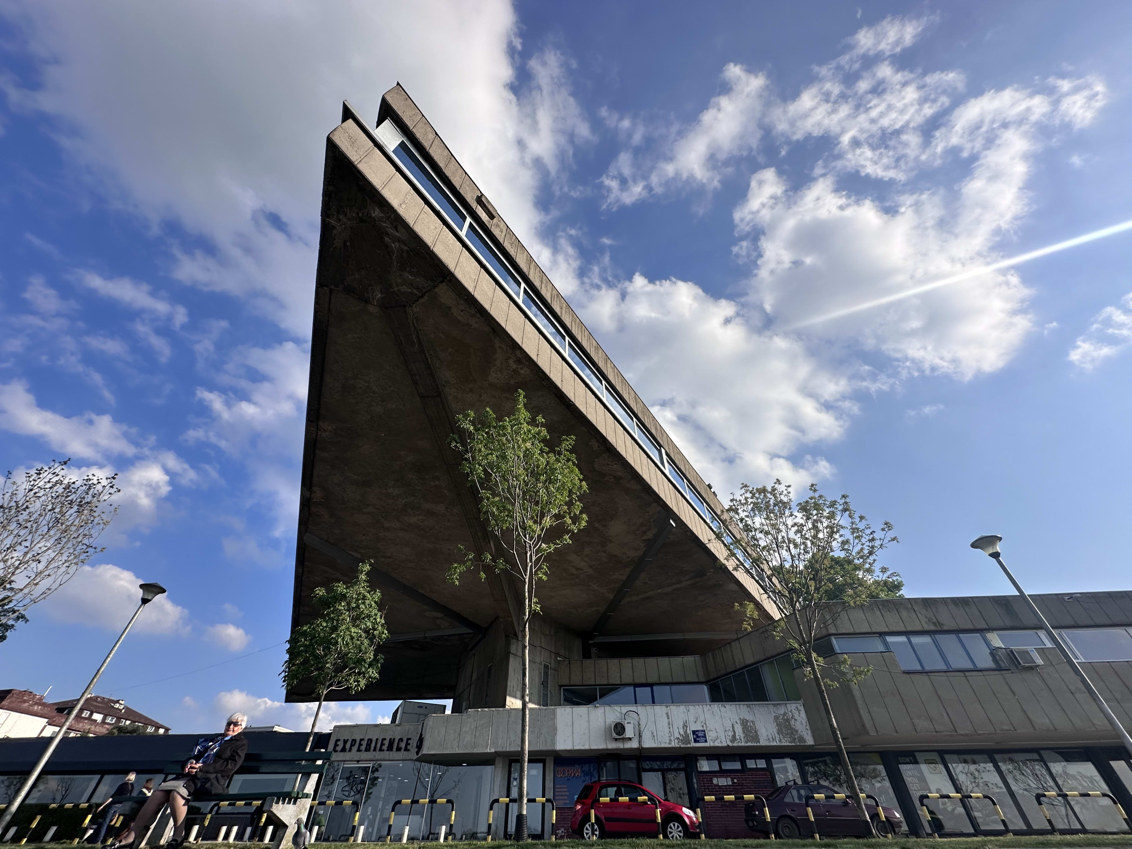 A striking example of Brutalist architecture from the Yugoslav era, showcasing a massive, concrete structure with sharp angles against a bright blue sky. This style is prominent in many Serbian cities, reflecting the country’s historical architectural trends. Keywords: facts about Serbia.