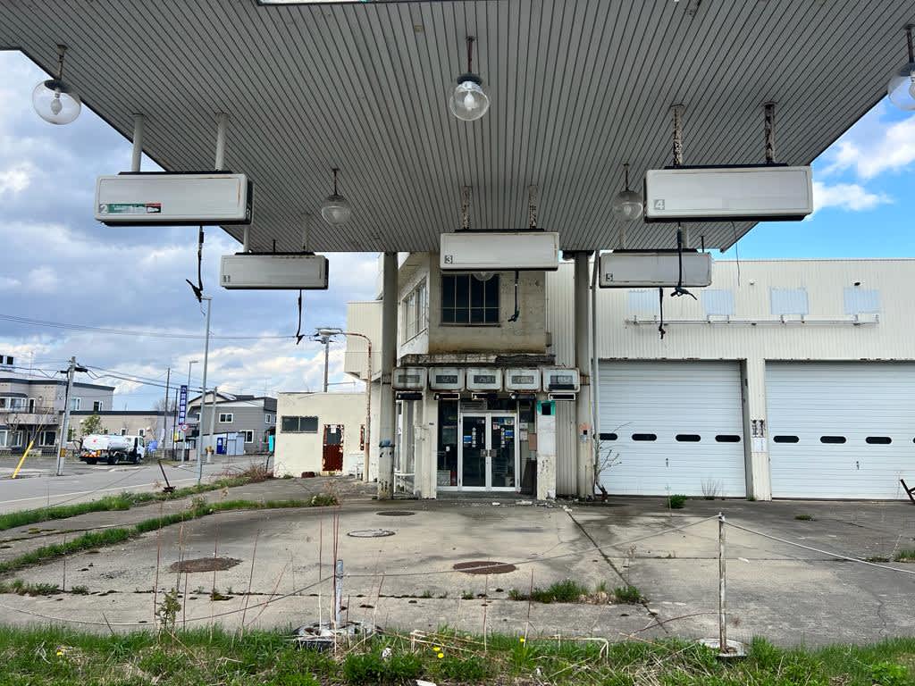 An abandoned and weathered service station in Kamifurano, Hokkaido, invoking a sense of past stories on a Hokkaido itinerary.