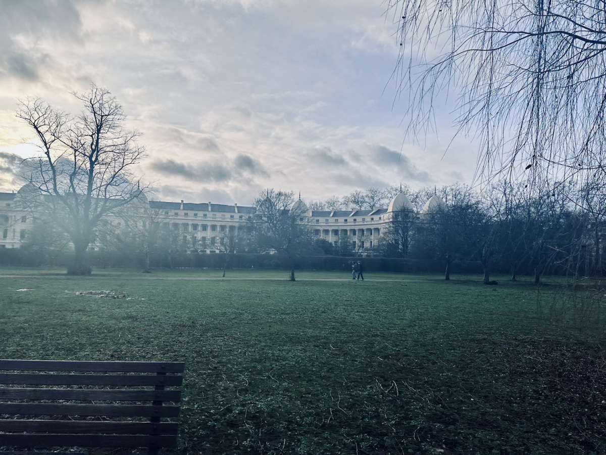 A serene winter day in Regent's Park with classical architecture in the background, capturing a tranquil side of Gay London.