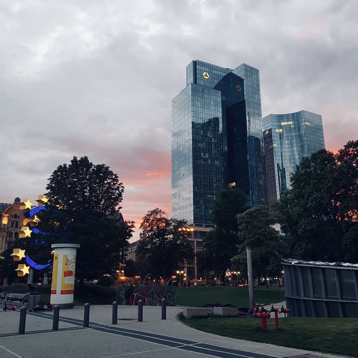 Twilight view of gay Frankfurt's skyline featuring the twin-towered Commerzbank headquarters, accented by an artistic star-shaped street installation.