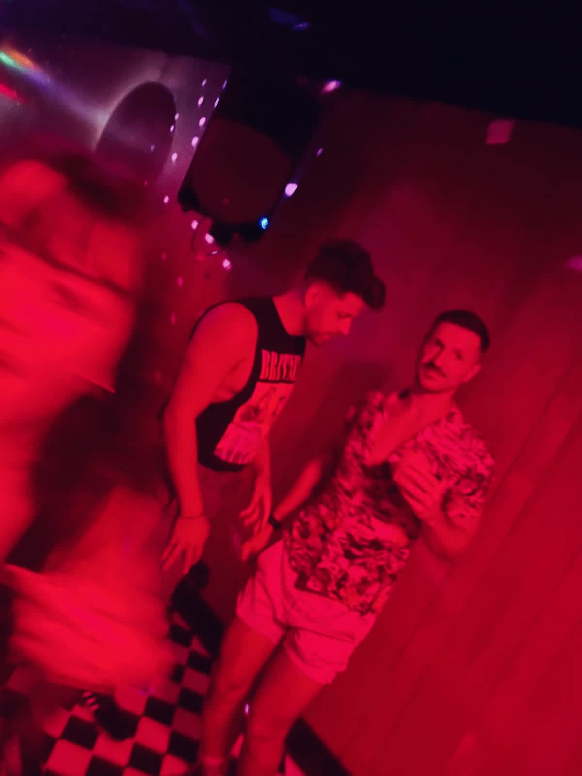 Blurred movement of two men enjoying their night at Dalston Superstore, a vibrant gay club in London known for its inclusive vibe.