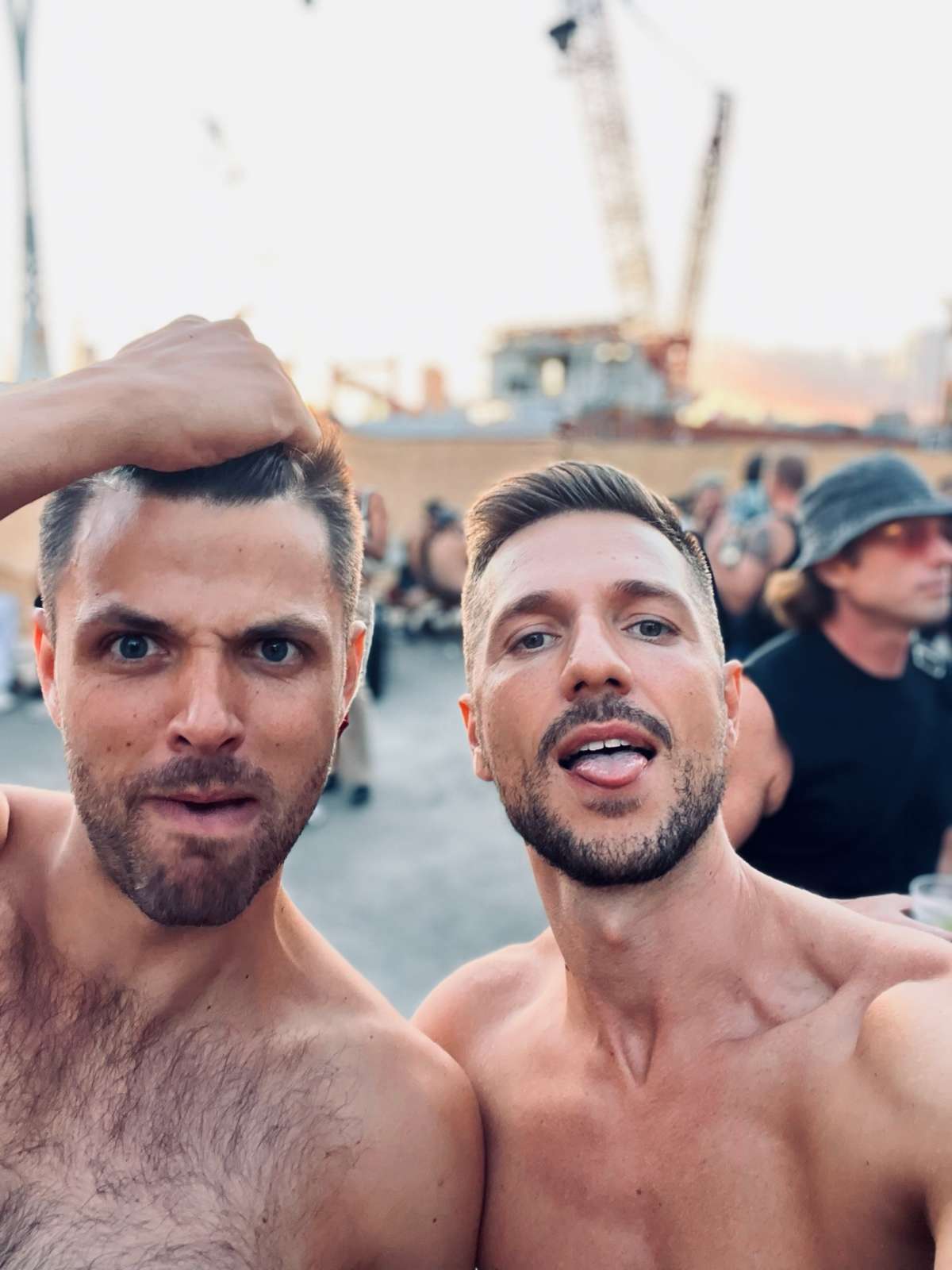 Two joyful men taking a selfie with the sun setting at Adonis, one of the best gay clubs in London.