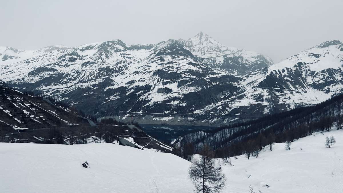 A tranquil scene of the serene Tignes valley and surrounding snow-draped mountains, capturing the natural beauty experienced during Gay Ski Week.