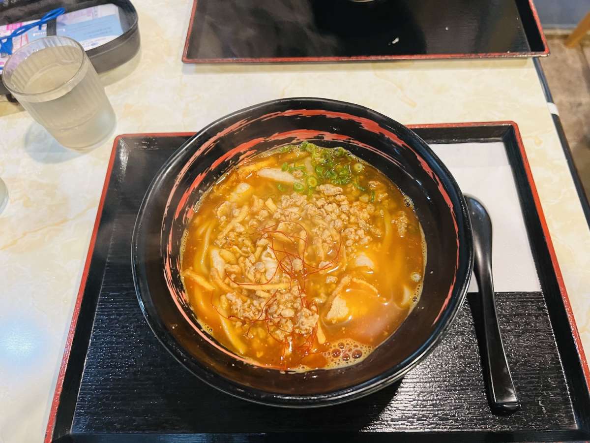 A bowl of spicy Ramen, a popular Nagasaki dish, with rich broth and toppings in a local restaurant setting.