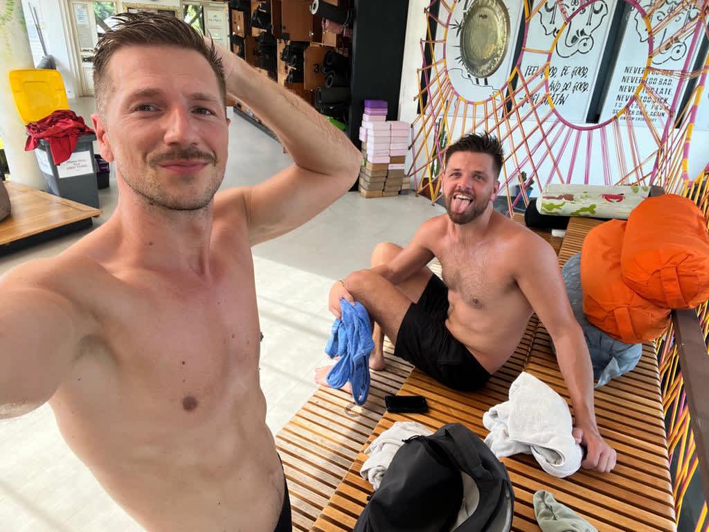 Two men participating in a hot yoga session at Ubud Yoga Centre in Bali, highlighting the health-oriented lifestyle embraced by digital nomads in Indonesia.