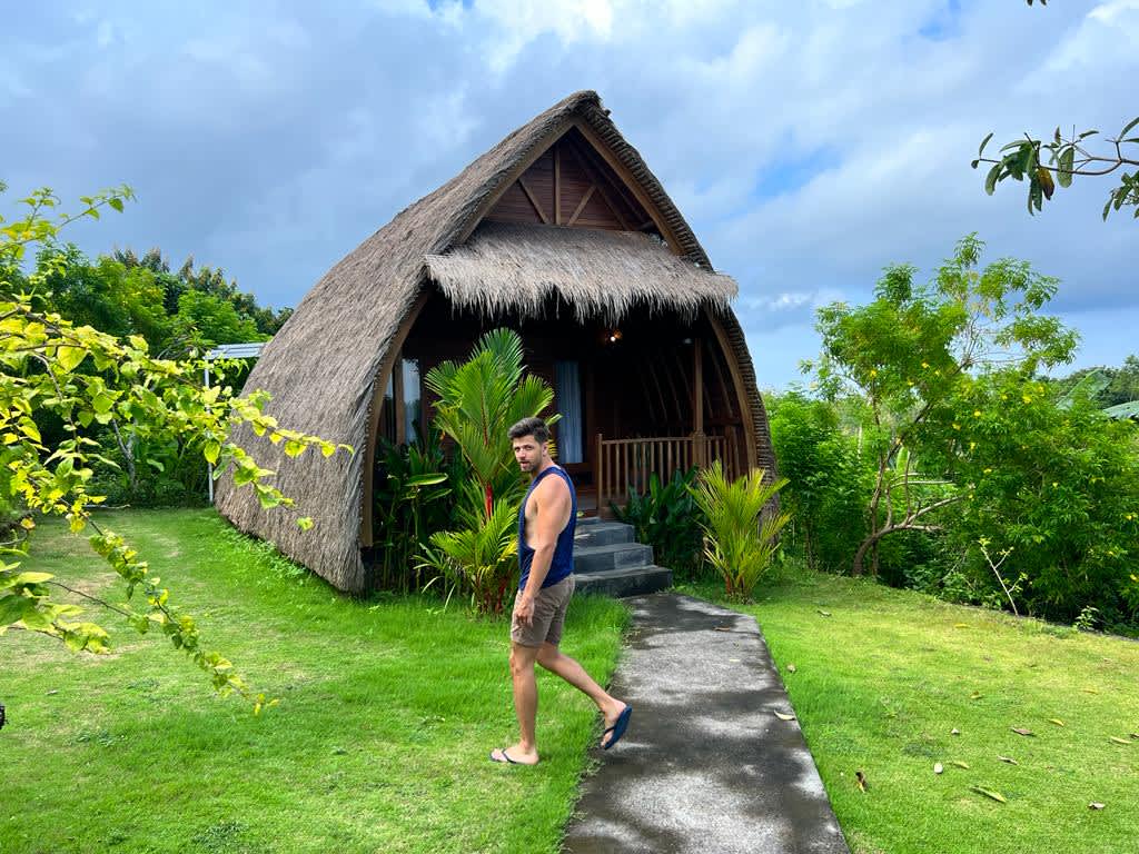 A rustic bungalow in Nusa Penida, Bali, set against a backdrop of lush tropical greenery, perfect for digital nomads seeking solitude and inspiration in Indonesia.