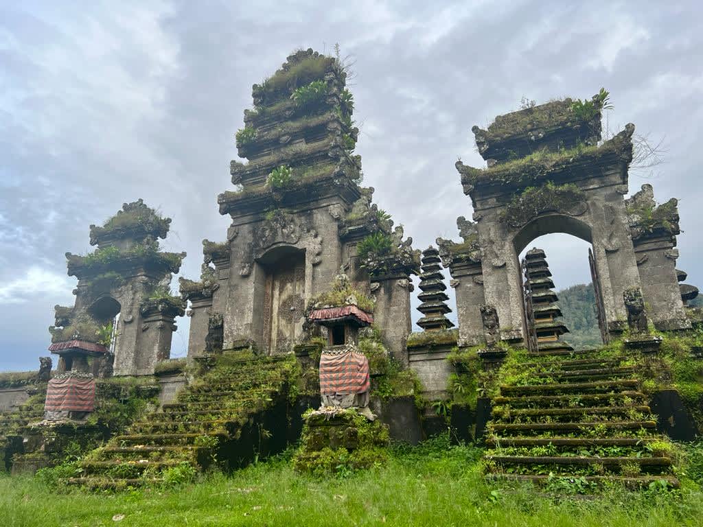 The ancient gates of Pura Ulun Danu Tamblingan in Bali, surrounded by mist and dense forest, a spiritual and picturesque site often visited by digital nomads exploring Indonesia.