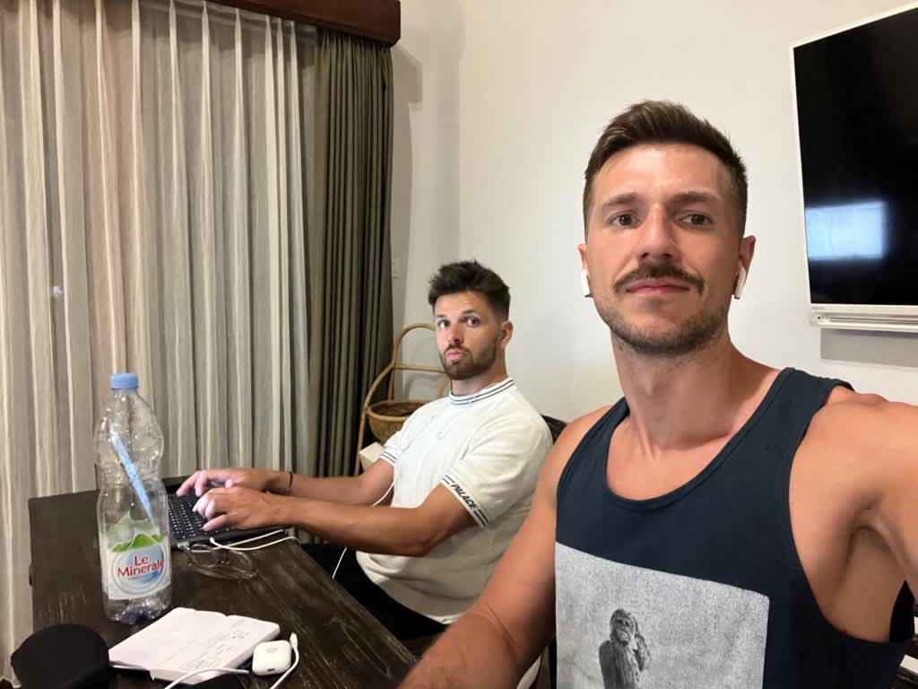 Two digital nomads working remotely from a minimalist styled home office in Bali, reflecting the modern work culture among expatriates in Indonesia.