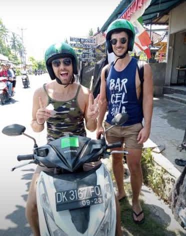 Two digital nomads riding scooters in Nusa Penida, Bali, showcasing the freedom and mobility enjoyed by remote workers exploring Indonesia's scenic routes.