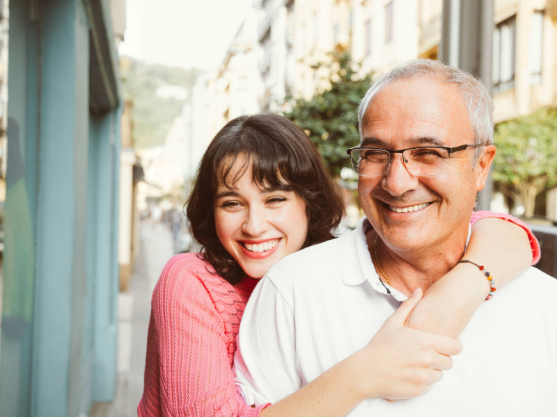 father and adult daughter smiling