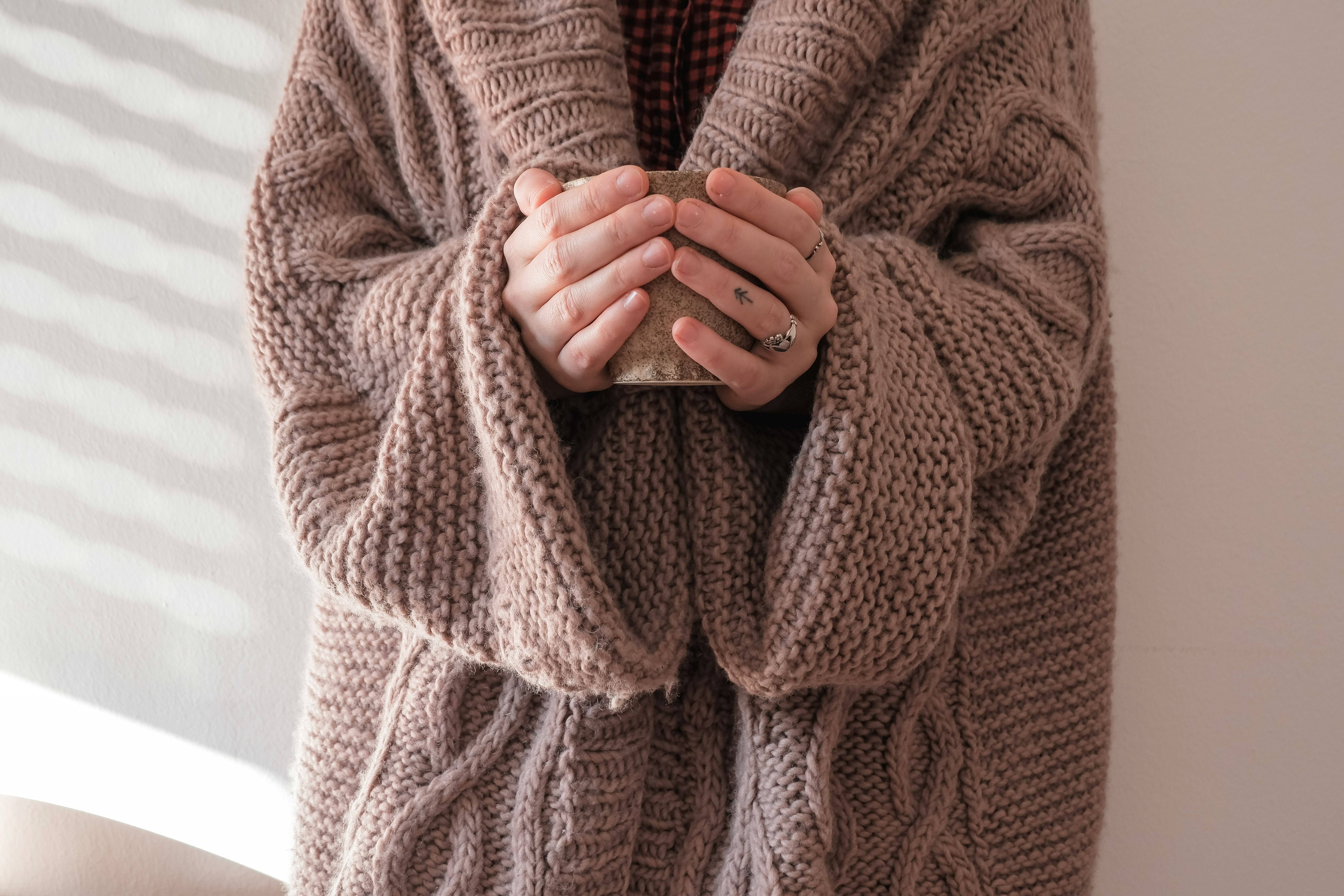 a close up of a lady's hands holding a mug.