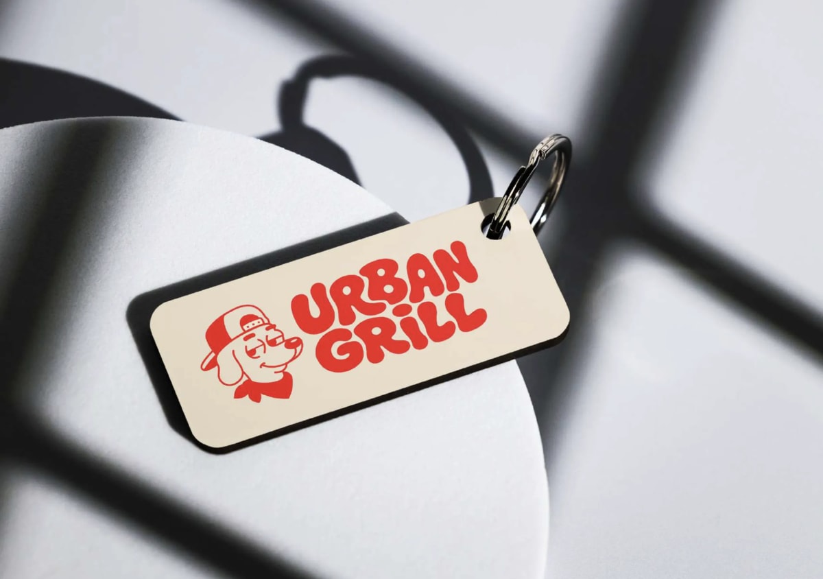 Llavero de Urban Grill con el logotipo del perro, sobre una mesa metálica, de Andrea Jurado, alumna de Diseño Gráfico y Motion Graphics en TRAZOS