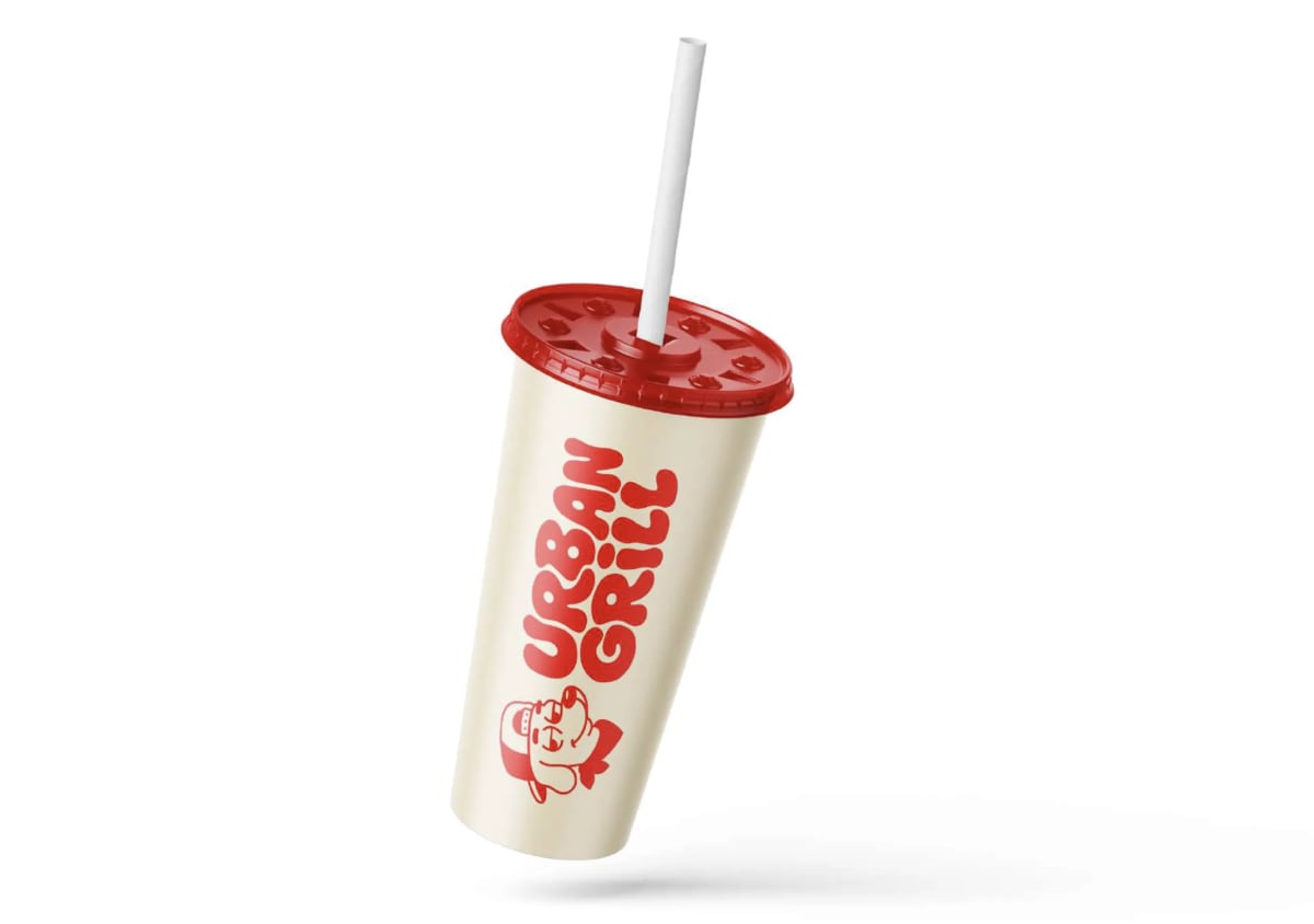 Vaso de refresco de Urban Grill con tapa roja y pajita, con el logotipo en vertical, de Andrea Jurado, alumna de Diseño Gráfico y Motion Graphics en TRAZOS