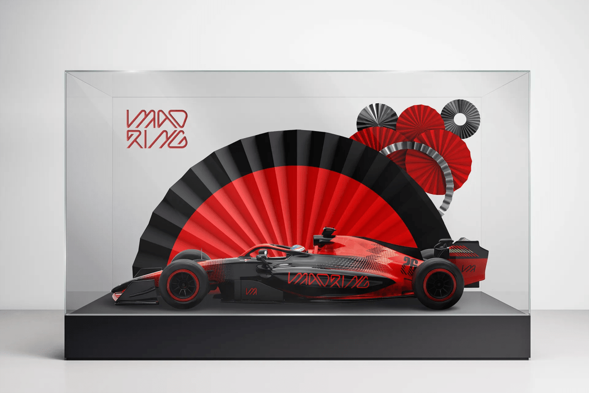 Vista frontal del coche de Fórmula 1 de la marca Madring en vitrina con abanicos rojos y negros, de Ana Romera, alumna de Diseño Gráfico y Motion Graphics en TRAZOS