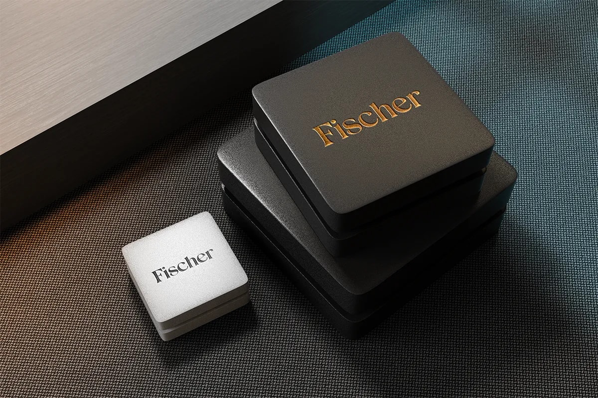 Cajas de merchandising con el logotipo dorado de Fischer, de Hugo Sánchez Herrero, alumno de Diseño Gráfico y Motion Graphics en TRAZOS