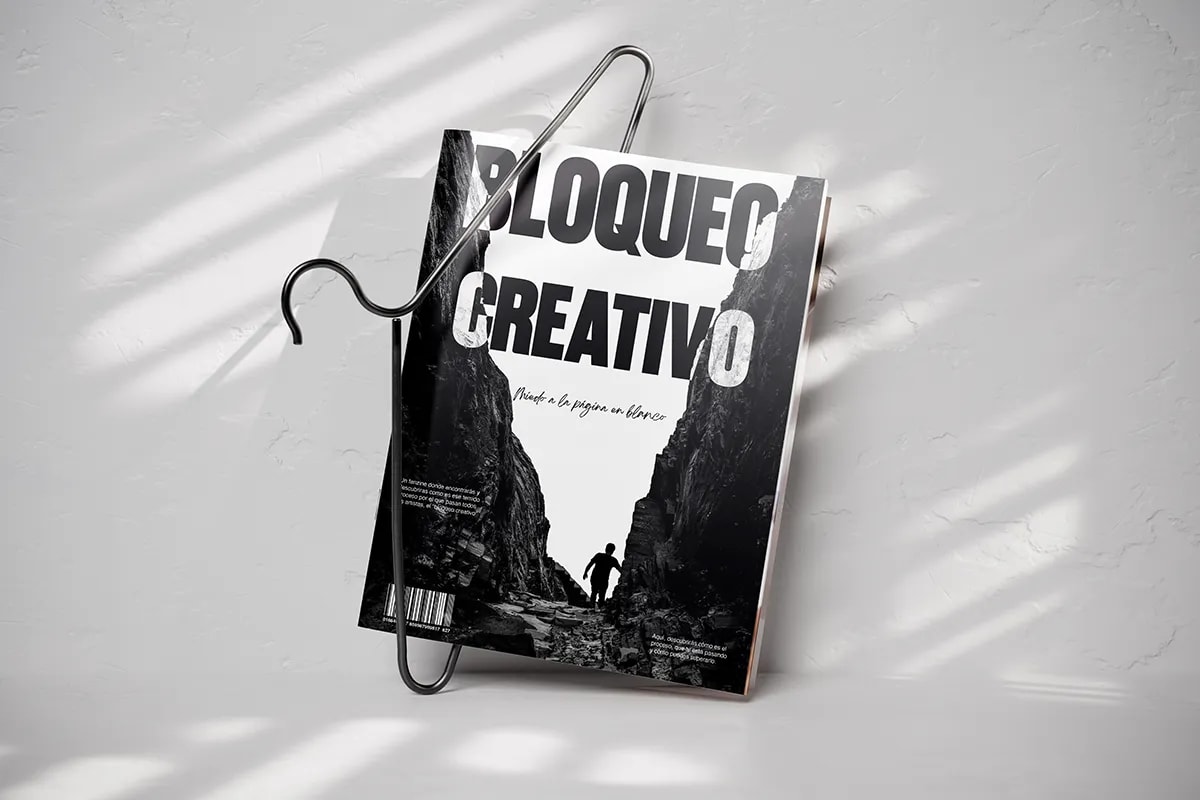 Revista Bloqueo Creativo colgada de una percha sobre pared clara, de Rita García, alumna de Diseño Gráfico y Motion Graphics en TRAZOS