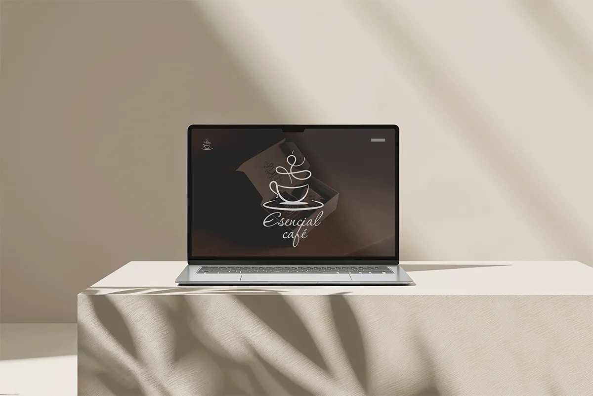 Diseño de la página web de Esencial Café mostrada en un portátil sobre una mesa, de Javier Lorite, alumno de Diseño Gráfico y Motion Graphics en TRAZOS