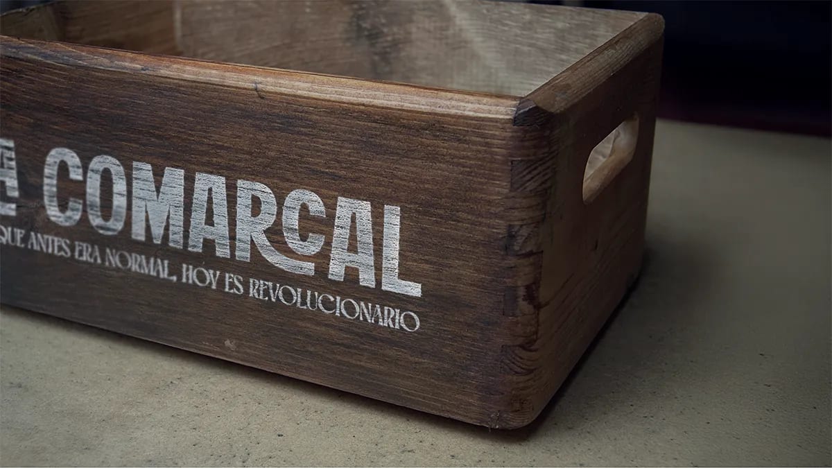 Tres botellas de vino de La Comarcal y otras marcas sobre fondo de piedra, de Maren Alberdi Hernández, alumna de Diseño Gráfico y Motion Graphics en TRAZOS