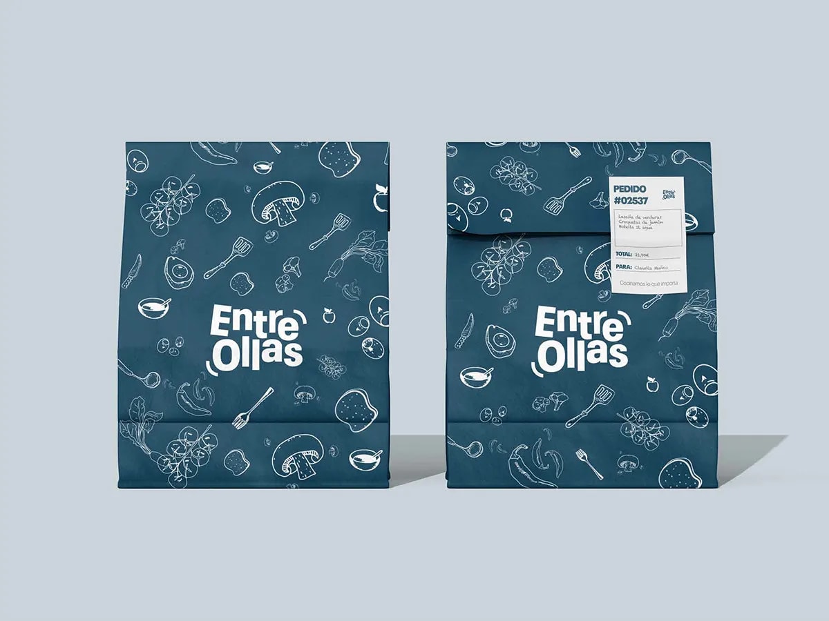 Bolsa de pedido azul de la marca Entre Ollas con etiqueta de pedido y patrón de alimentos, de Marina Gabilondo Calleja, alumna de Diseño Gráfico y Motion Graphics en TRAZOS