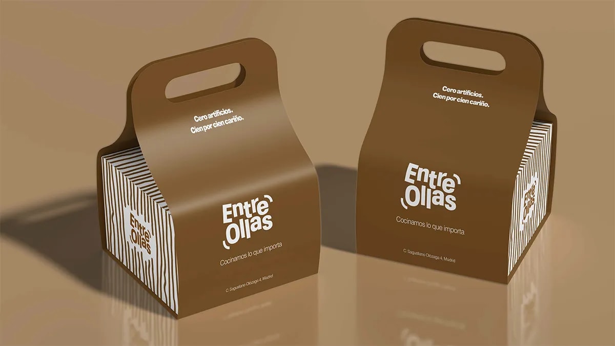 Cajas de cartón con asa para llevar de la marca Entre Ollas, de Marina Gabilondo Calleja, alumna de Diseño Gráfico y Motion Graphics en TRAZOS