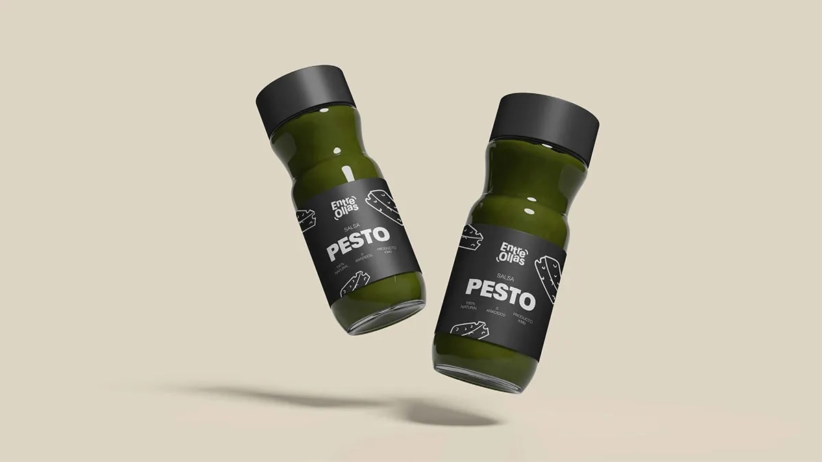Botellas de salsa pesto de la marca Entre Ollas con etiqueta oscura, de Marina Gabilondo Calleja, alumna de Diseño Gráfico y Motion Graphics en TRAZOS