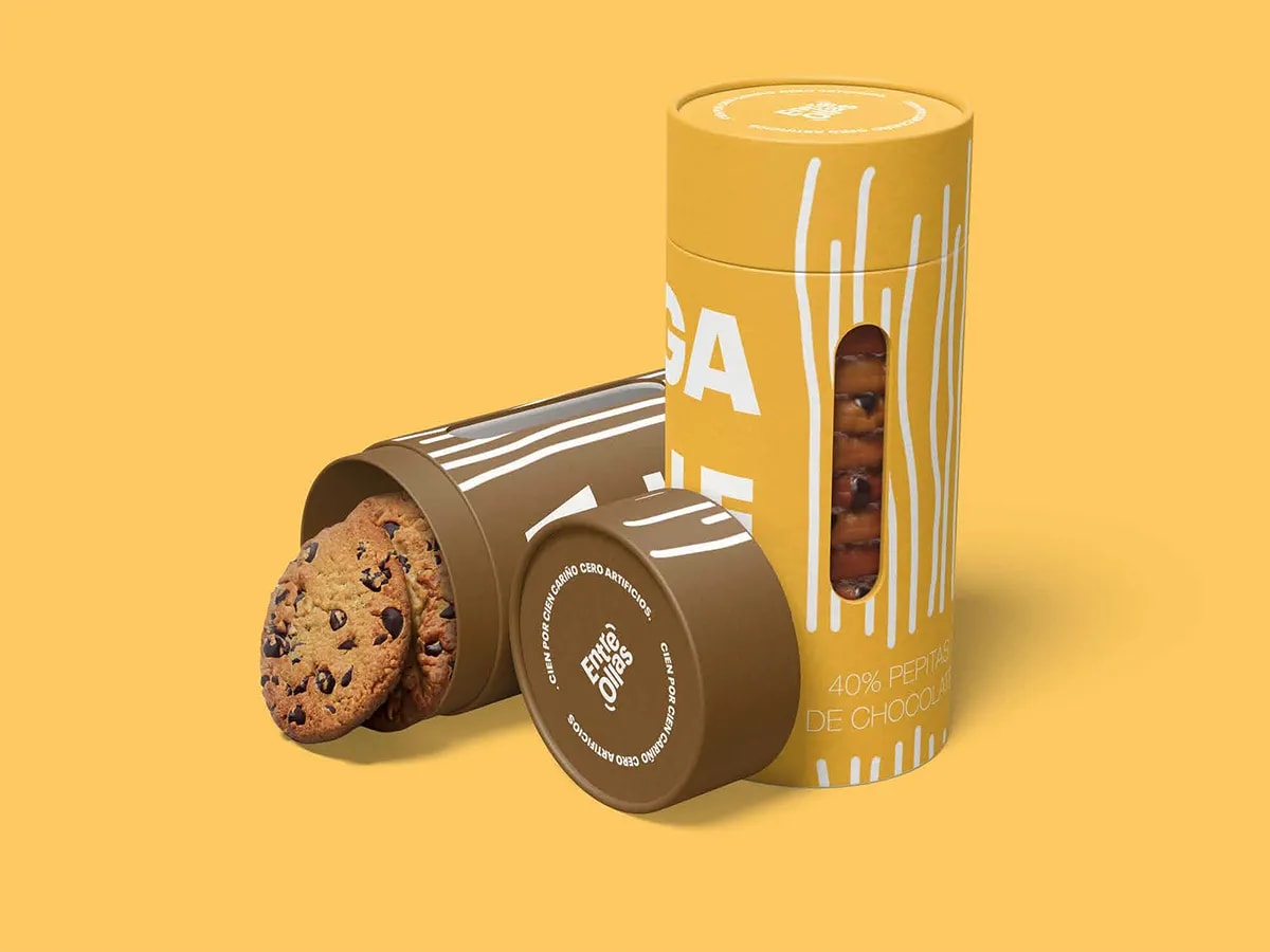 Tubos de cartón de galletas de la marca Entre Ollas en amarillo y marrón con ventana de producto, de Marina Gabilondo Calleja, alumna de Diseño Gráfico y Motion Graphics en TRAZOS