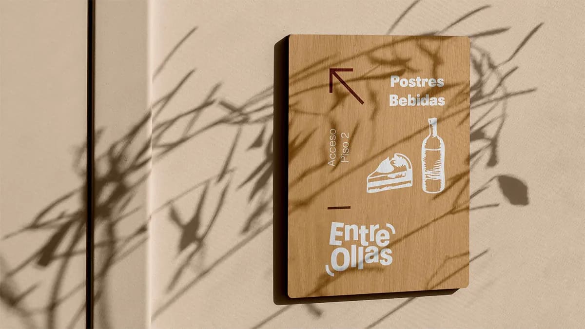 Señalética de pared en madera de la marca Entre Ollas indicando postres y bebidas, de Marina Gabilondo Calleja, alumna de Diseño Gráfico y Motion Graphics en TRAZOS