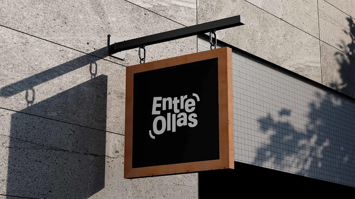 Rótulo banderola colgante de la marca Entre Ollas en una fachada, de Marina Gabilondo Calleja, alumna de Diseño Gráfico y Motion Graphics en TRAZOS