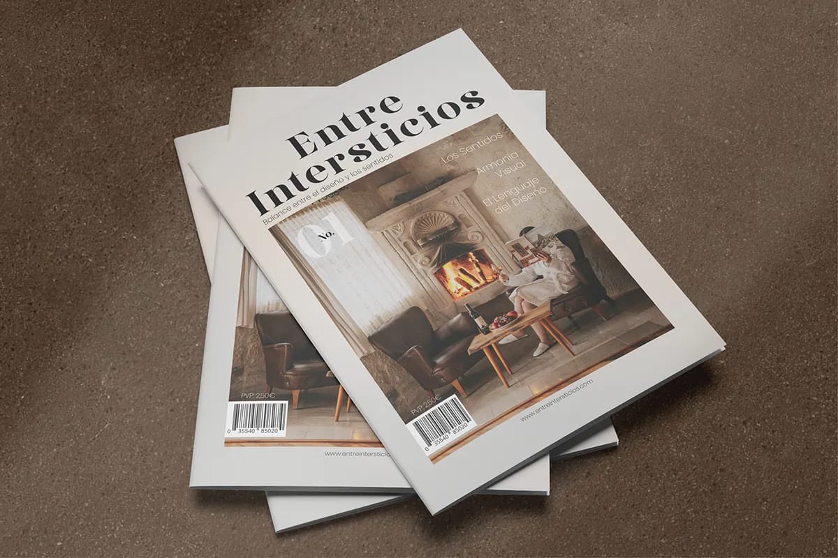 Dos ejemplares apilados de la revista «Entre Intersticios» mostrando la portada, de Diana Barrero, alumna de Diseño Gráfico y Motion Graphics en TRAZOS