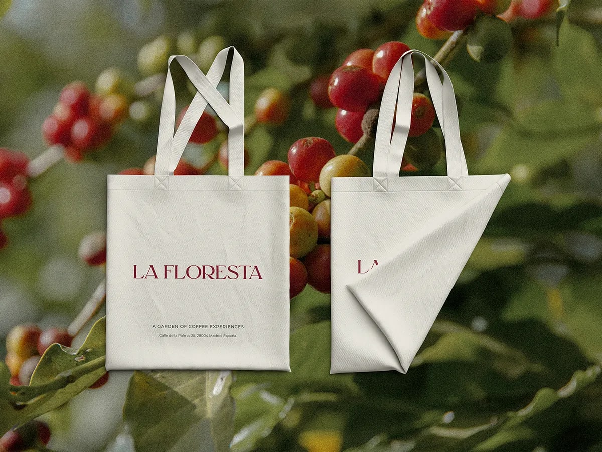 Bolsas de tela de La Floresta sobre un cafetal con cerezas de café, de Fabiana Moure, alumna de Diseño Gráfico y Motion Graphics en TRAZOS