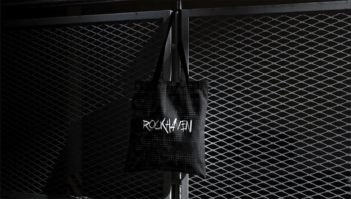 Bolsa de tela negra de RockHaven colgada de una verja metálica, de Verónica Guzmán, alumna de Diseño Gráfico y Motion Graphics en TRAZOS