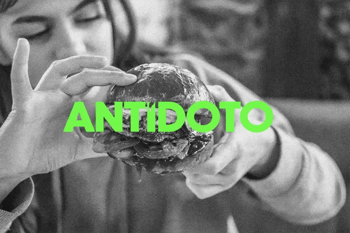 Cartel en blanco y negro de la marca Antídoto con una hamburguesa y logotipo verde, de Elena Toledo, alumna de Diseño Gráfico y Motion Graphics en TRAZOS