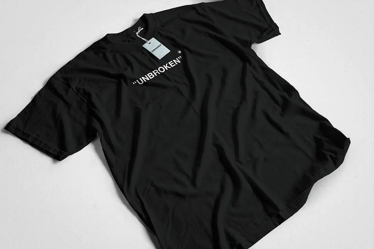 Camiseta negra del Unbroken Festival con el logotipo en blanco y etiqueta de marca, de María Delgado, alumna de Diseño Gráfico y Motion Graphics en TRAZOS