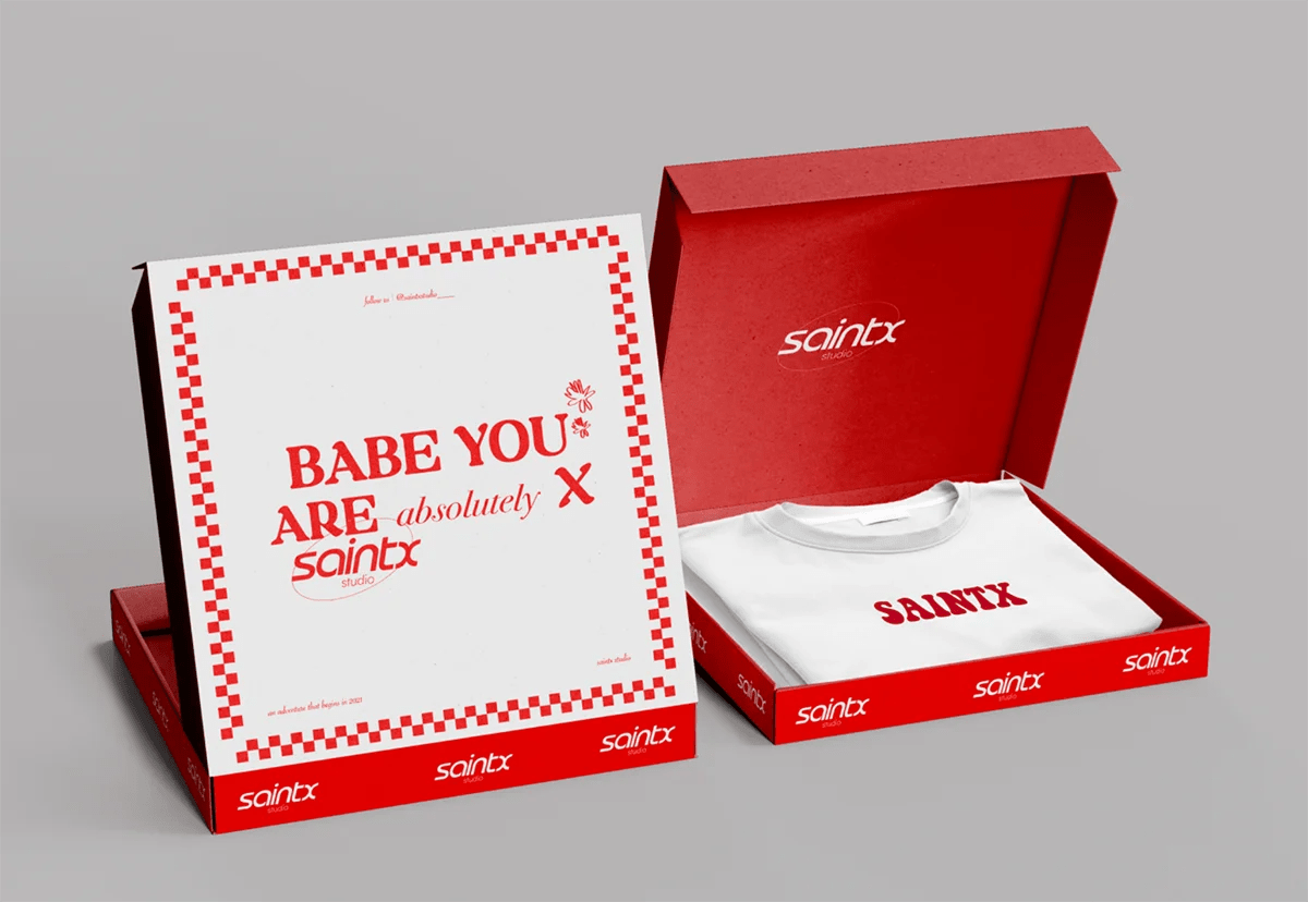 Diseño de packaging de la marca saintx studio con caja roja y camiseta serigrafiada, de Elena Toledo Walls, alumna de UX/UI/Web en TRAZOS