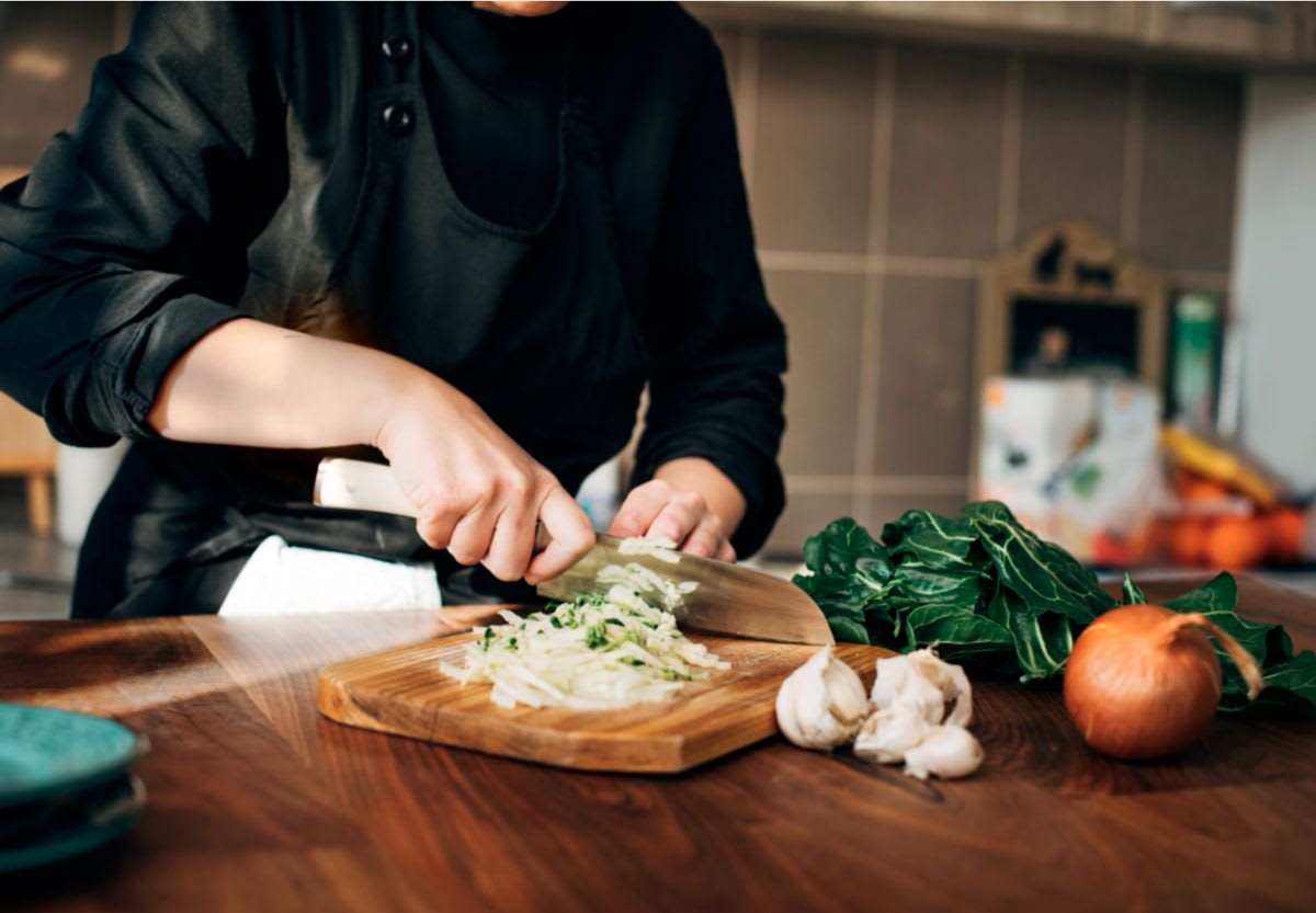 Foto de una persona cortando verduras en la cocina usada en el proyecto de la app Pomelo, de Cristóbal Bravo González, alumno de UX/UI/Web en TRAZOS
