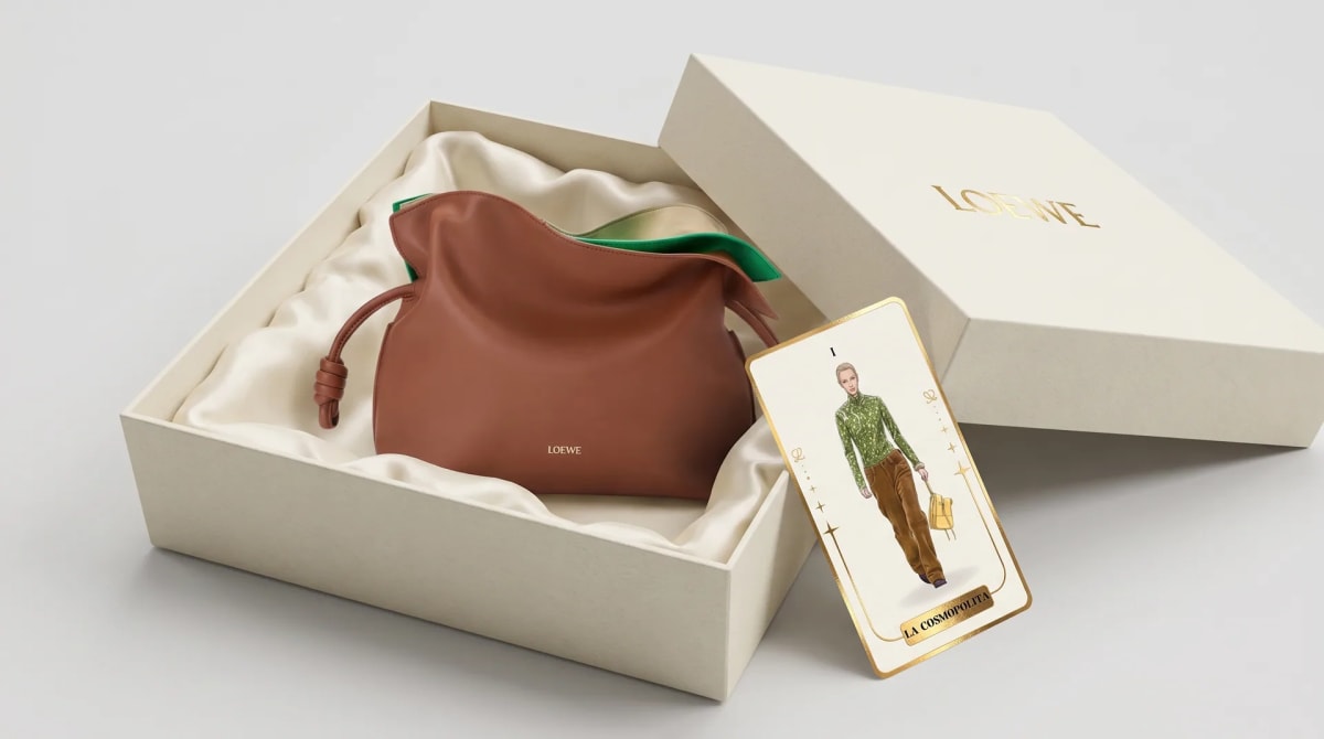 Bolso de piel Loewe en su caja forrada de satén, junto a la carta de tarot La Cosmopolita, de Katherine Valencia, alumna de Diseño Gráfico y Motion Graphics en TRAZOS