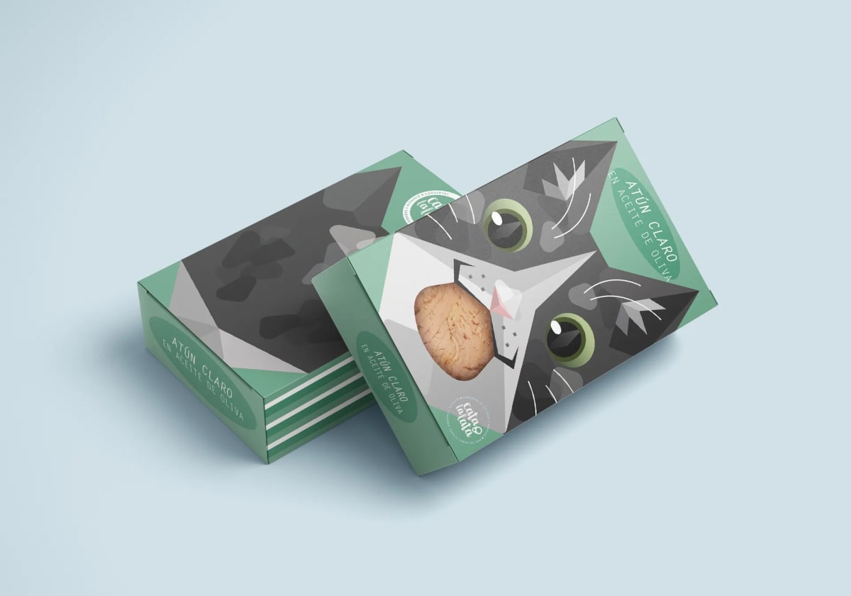 Bodegón de dos cajas de atún claro Cato la lata sobre fondo azul, con el gato gris ilustrado, de Paula Valentina Trotta, alumna de Diseño Gráfico y Motion Graphics en TRAZOS