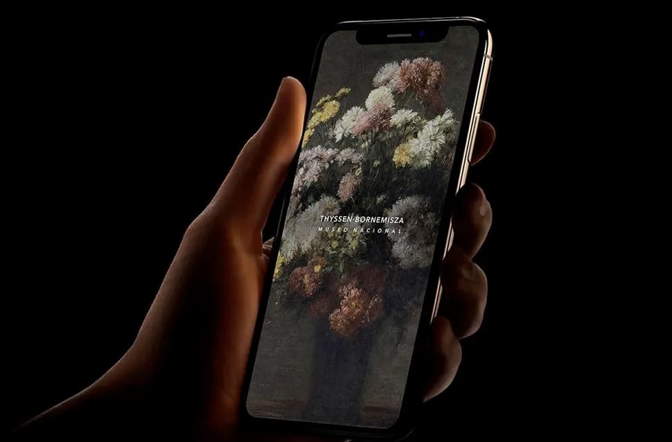 Mano sosteniendo un móvil con la app del Museo Thyssen-Bornemisza mostrando una pintura floral, tecnologías emergentes, módulo del Máster Avanzado en Programación Web y Apps de TRAZOS, escuela de arte digital en Madrid