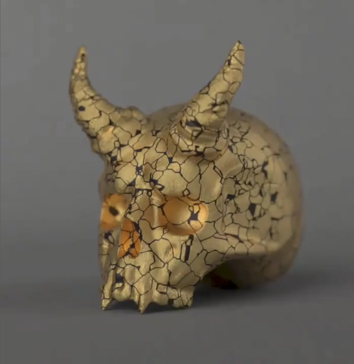 Render 3D de una calavera dorada con cuernos y textura craquelada, trabajo de Jorge Asso, profesor de Motion Graphics de TRAZOS, escuela de arte digital en Madrid