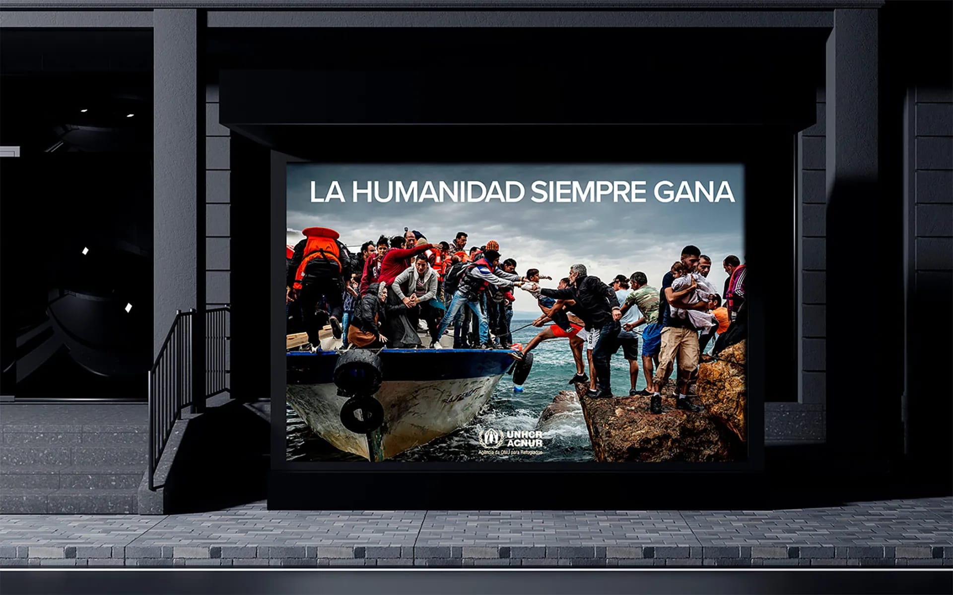 Montaje fotográfico de la campaña de ACNUR 'La humanidad siempre gana' en un mupi urbano, trabajo de Rafael Quílez, profesor de Retoque Digital y Dirección de Arte de TRAZOS, escuela de arte digital en Madrid