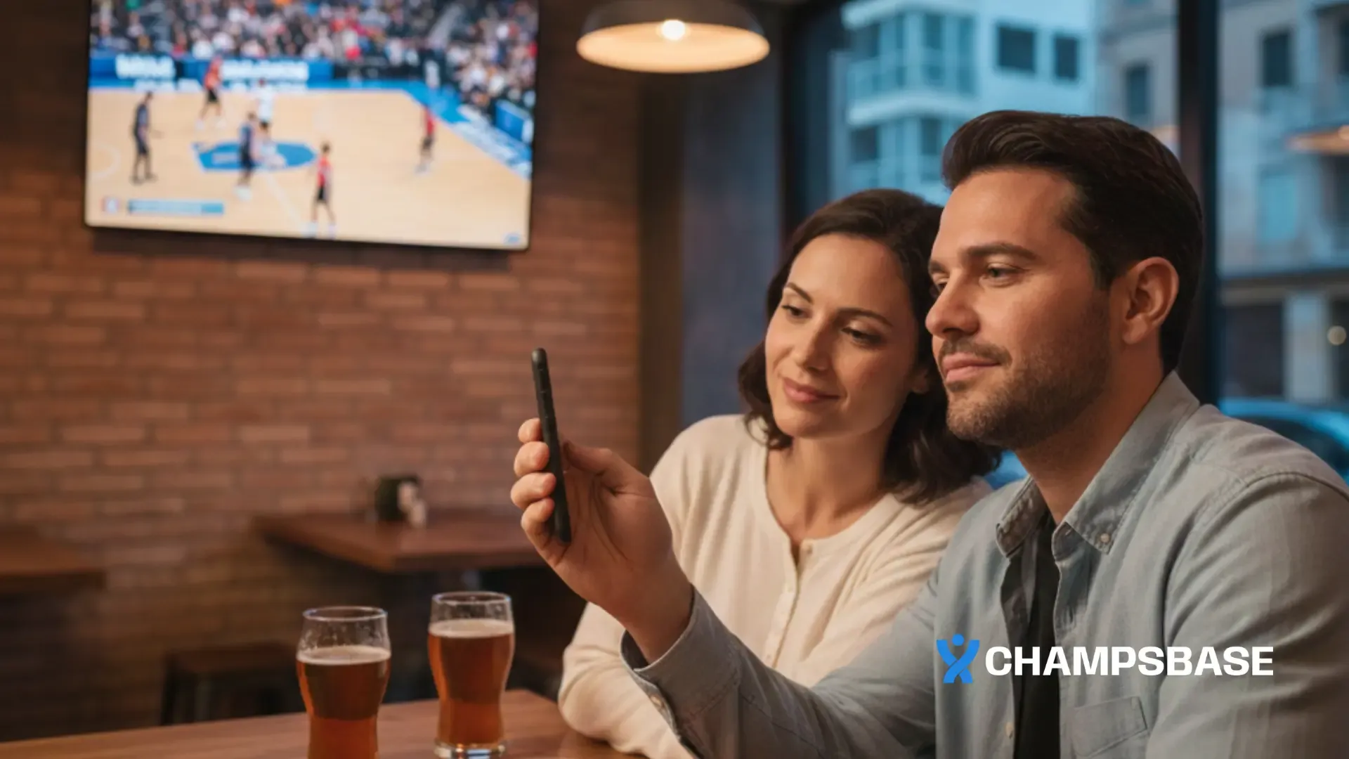 Casal brasileiro em bar moderno acompanhando basquete na TV enquanto faz aposta esportiva pelo celular.