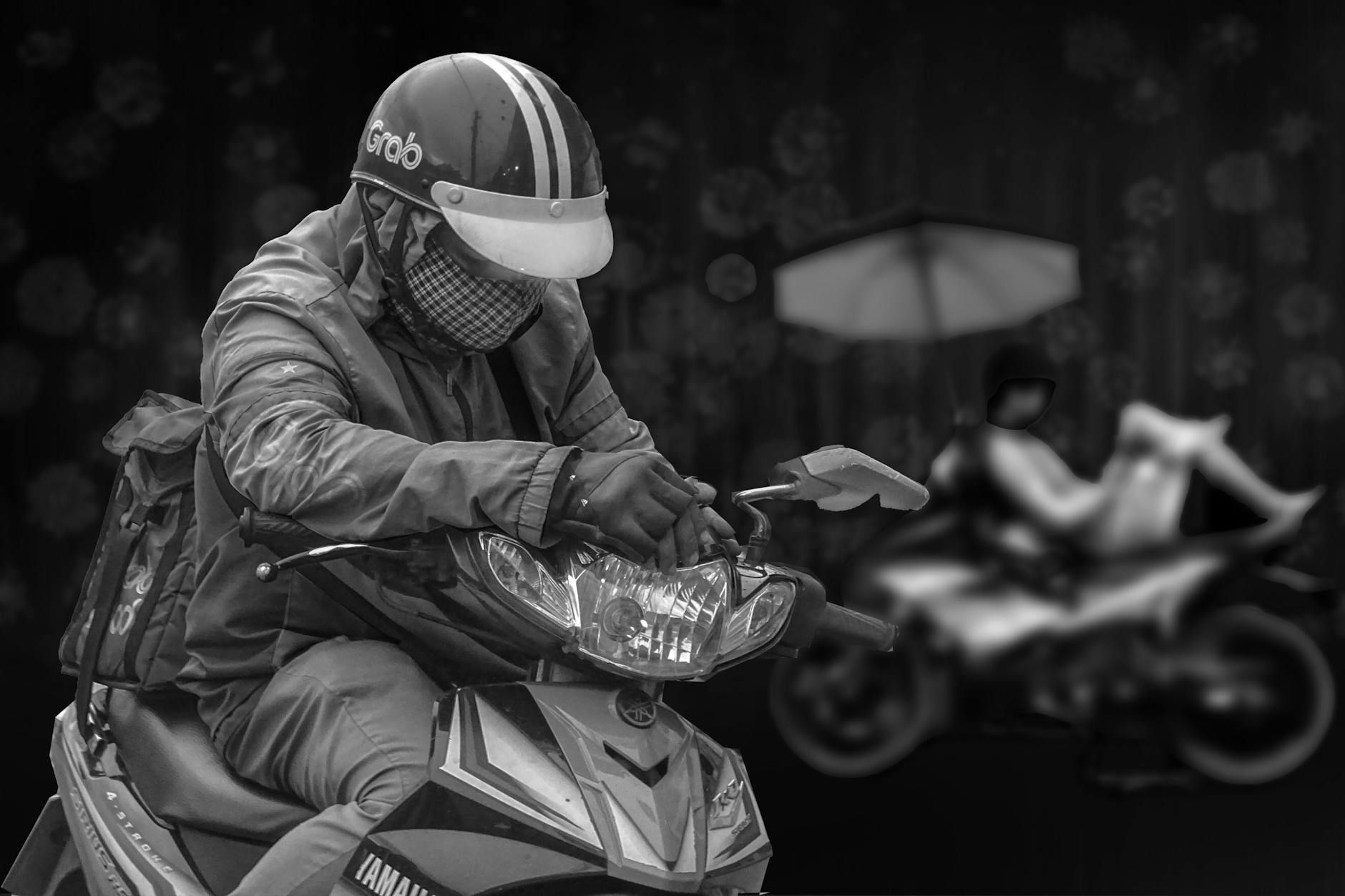 A delivery rider on a motorbike taking a break in Dĩ An, Vietnam.