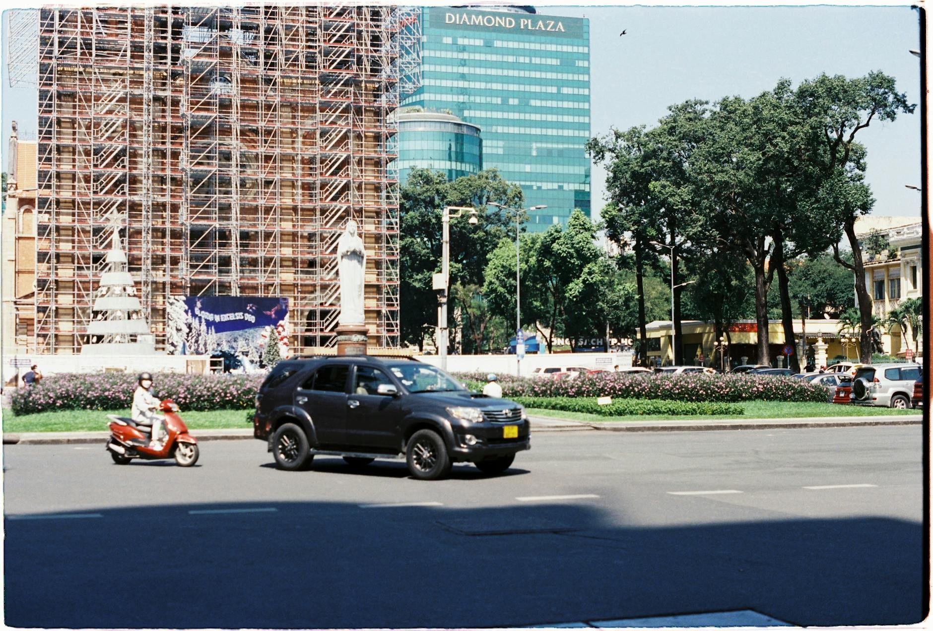 Dynamic street view with cars and motorbikes in front of Diamond Plaza.