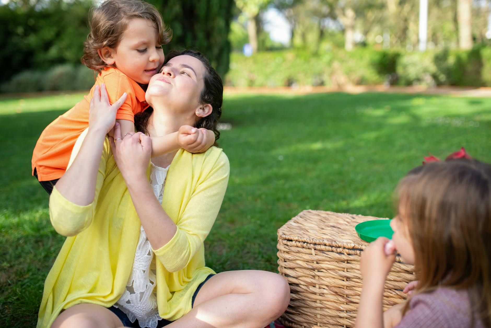 Family enjoying a sunny day picnic in a park, showcasing love and bonding.