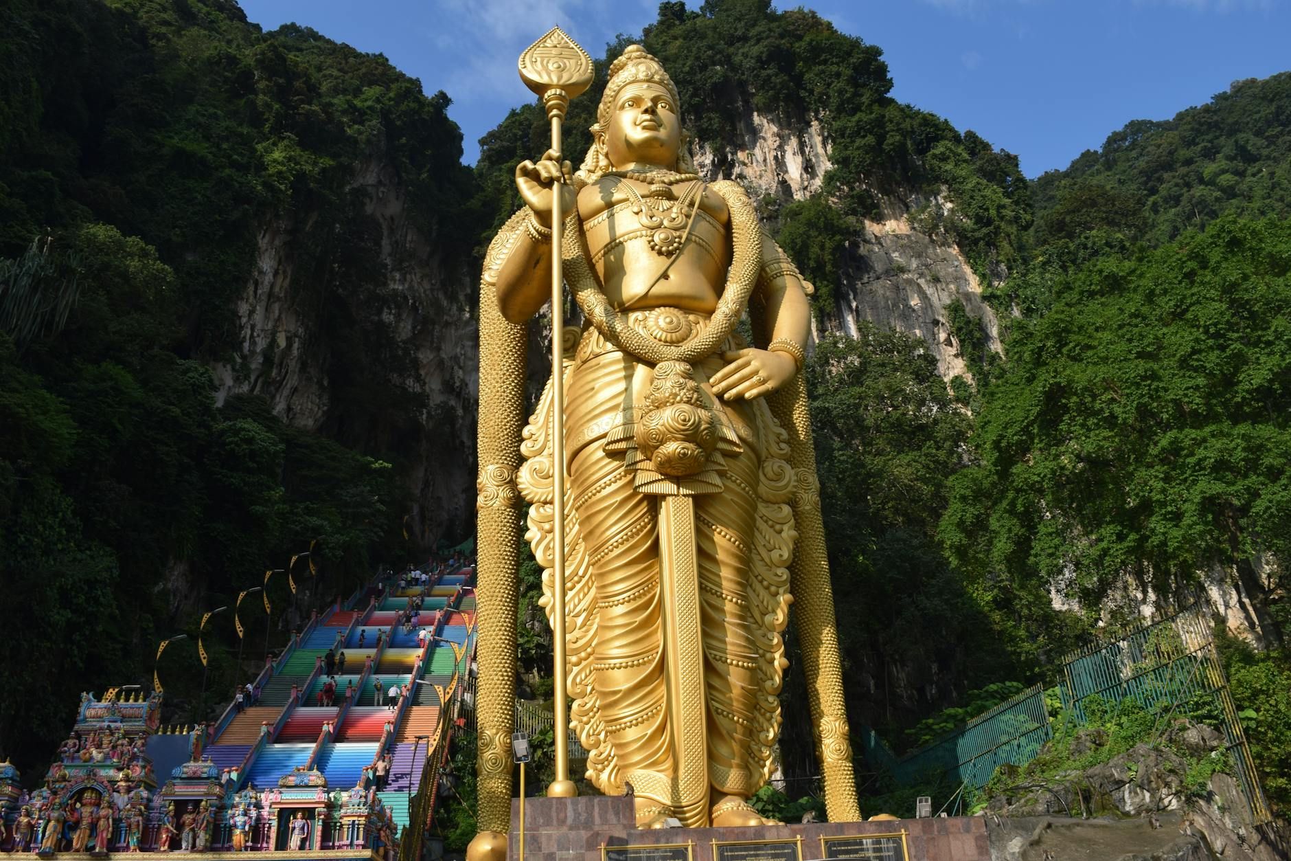 Majestic view of the golden Lord Murugan statue at Batu Caves, a cultural landmark in Malaysia.