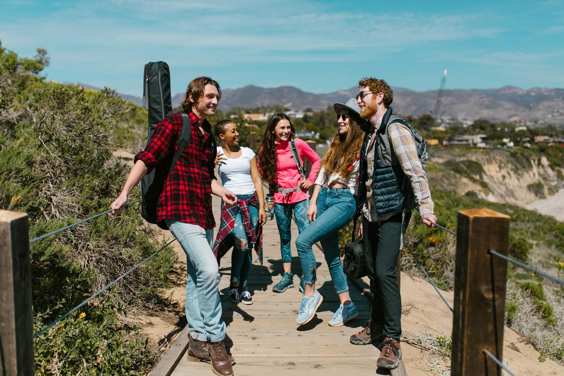 A group of young friends enjoying a hike on a sunny day in the mountains.