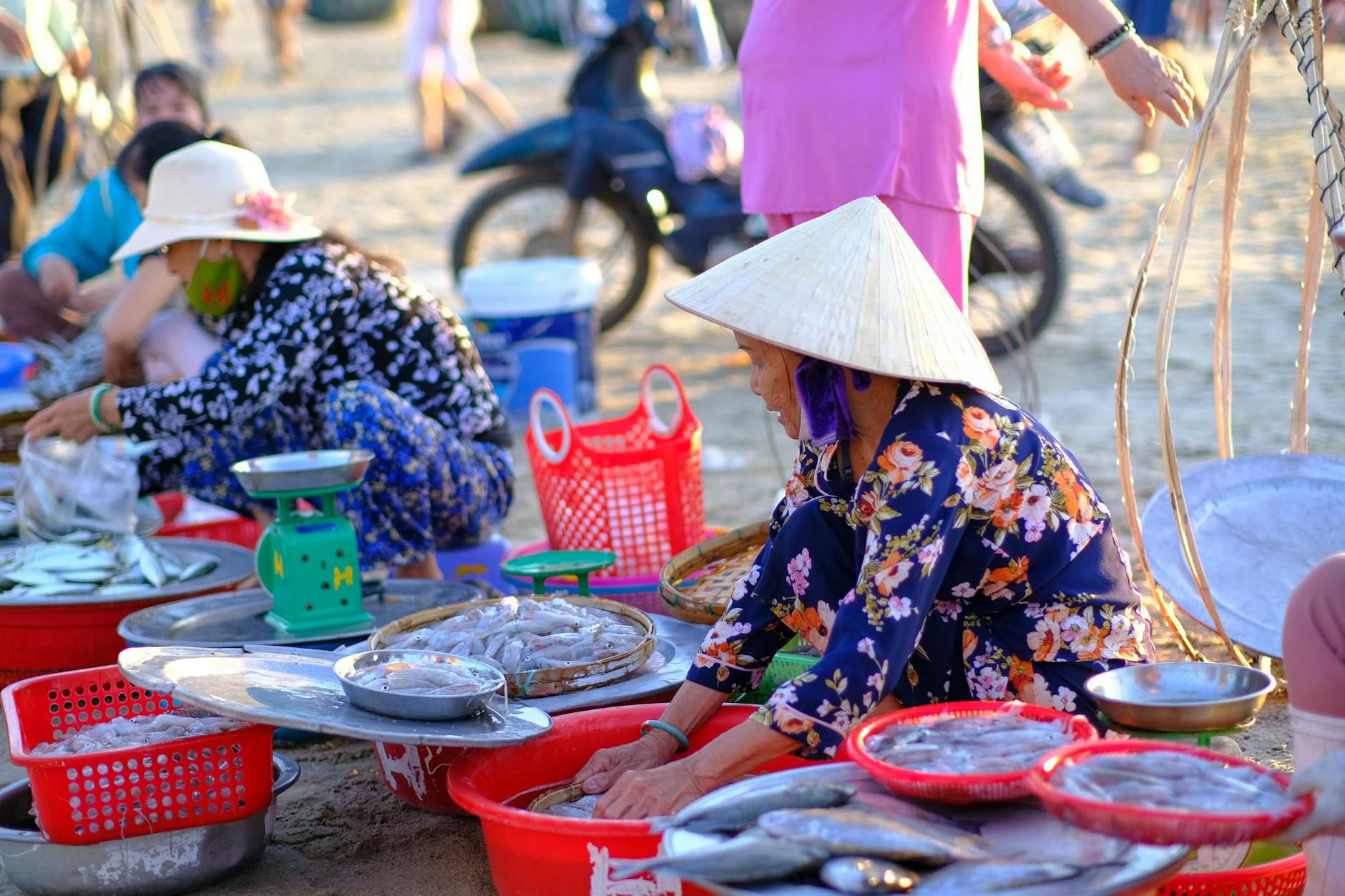 Vibrant scene of local women selling fresh seafood at Da Nang beach market.