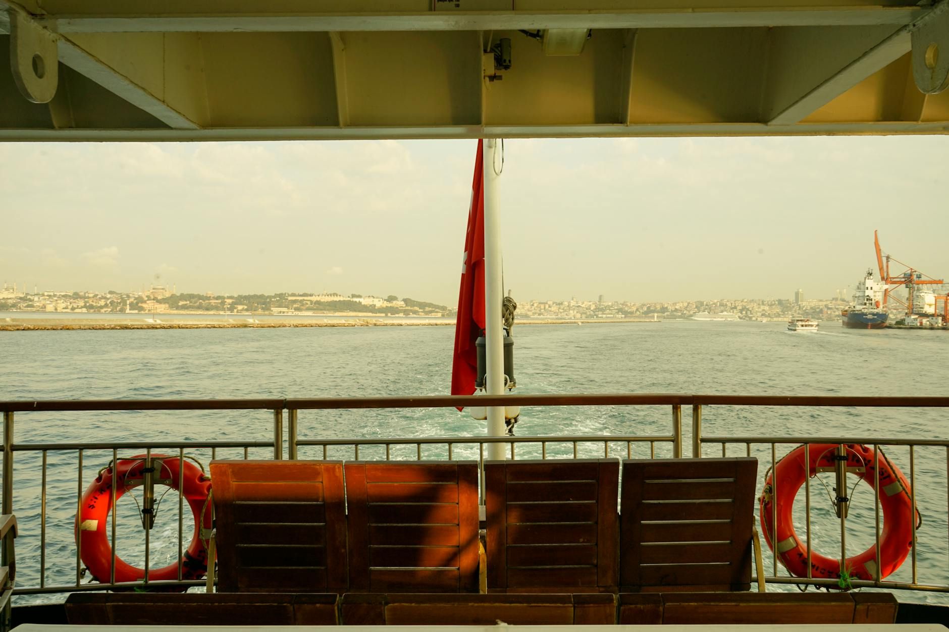 A serene view from a ferry with cityscape and sea, capturing Istanbul's harbor beauty.