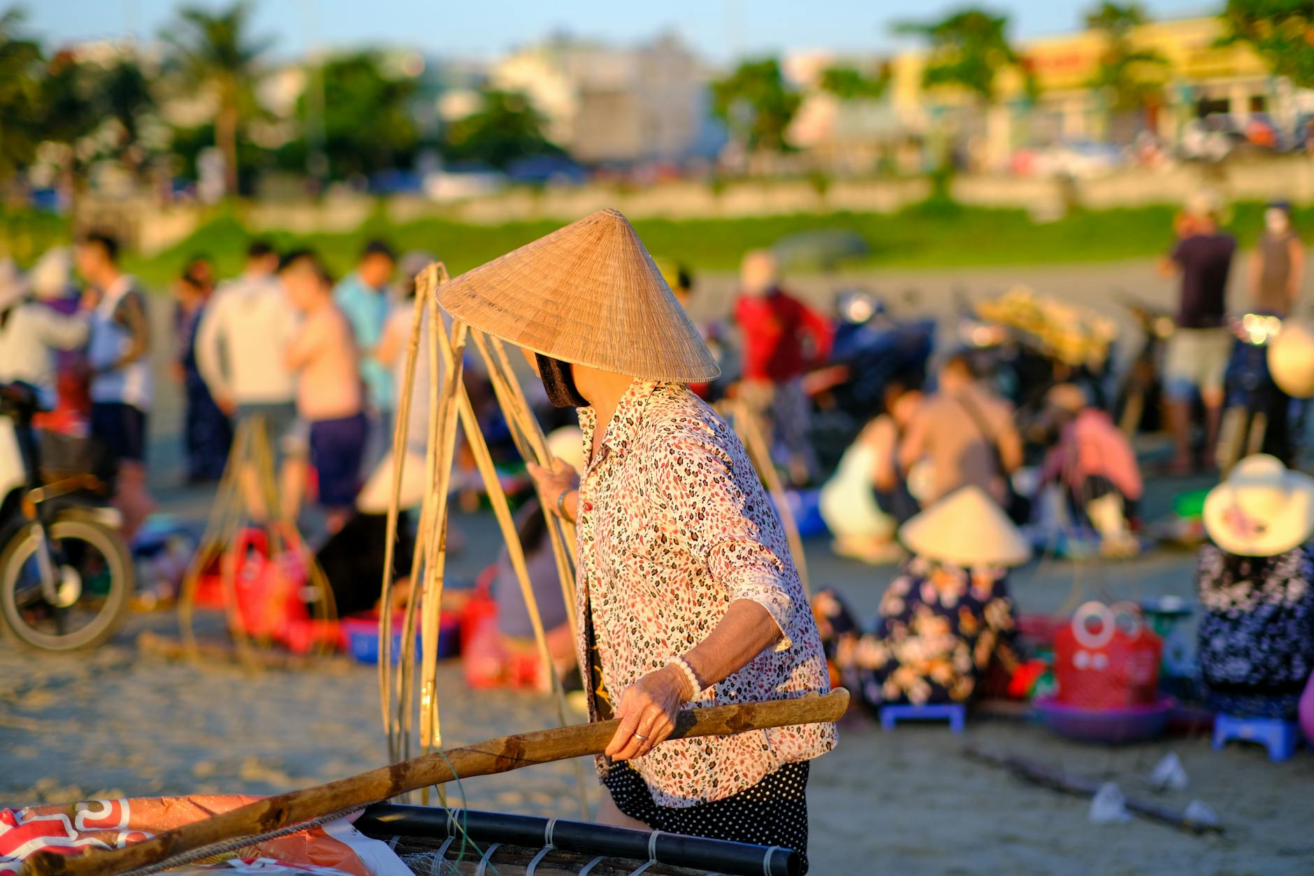 A vibrant scene of local life at a Vietnamese beach market during sunrise, showcasing cultural attire.